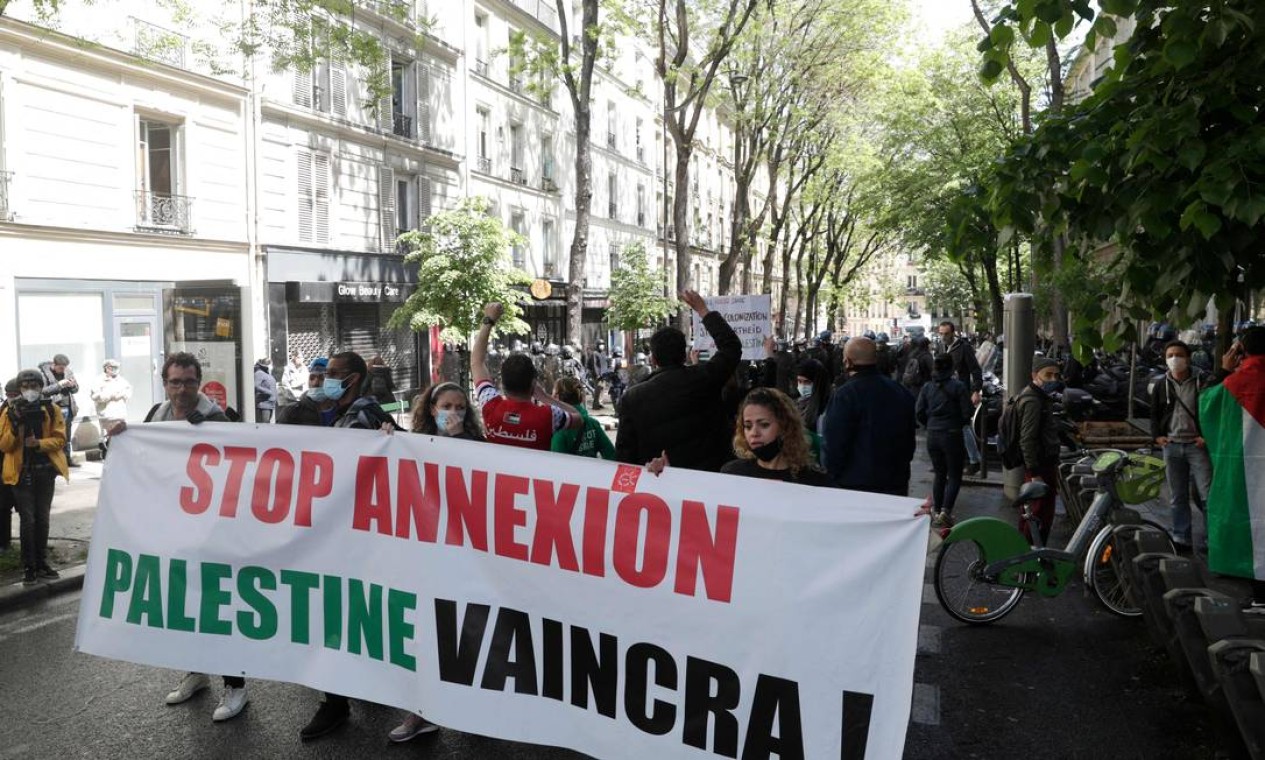 Manifestantes seguram uma faixa que diz 'pare a anexação - a Palestina vai vencer' durante uma manifestação em solidariedade aos palestinos, em Paris, França Foto: GEOFFROY VAN DER HASSELT / AFP - 15/05/2021