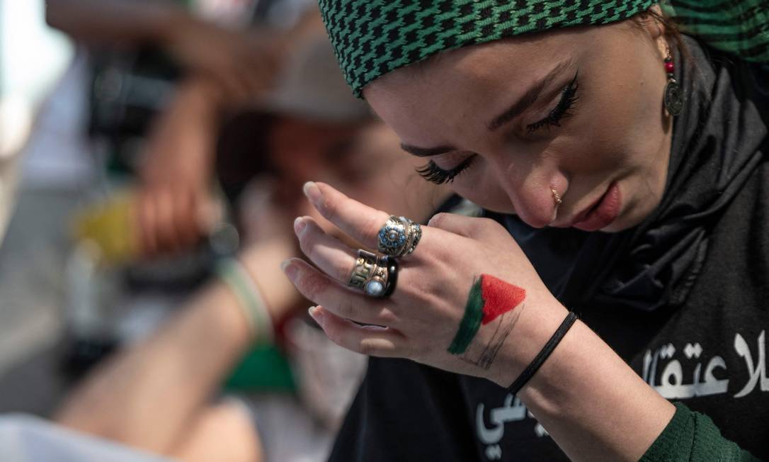 Mulher chora enquanto os nomes das crianças mortas nos recentes combates em Gaza são lidos em voz alta em ato de apoiadores da Palestina em frente à Embaixada de Israel, na capital dos EUA, Washington Foto: ANDREW CABALLERO-REYNOLDS / AFP - 18/05/2021