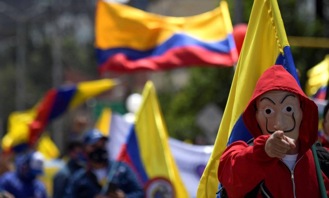 Manifestante vestindo o macacão vermelho e a máscara de Dali da série espanhola de sucesso da Netflix, "La Casa de Papel", protesta contra o governo do presidente colombiano Ivan Duque, em Bogotá Foto: RAUL ARBOLEDA / AFP