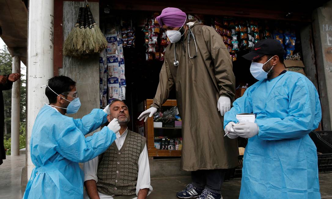 Trabalhador de saúde coleta uma amostra de esfregaço nasal de um homem para um teste de Covid-19 no distrito de Budgam, no centro da Caxemira, em maio de 2021 Foto: DANISH ISMAIL / REUTERS