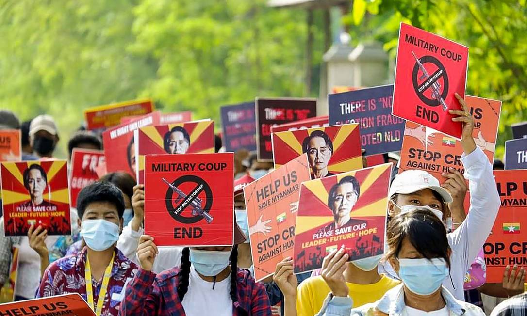 Manifestantes seguram cartazes com o rosto de Aung San Suu Kyi, líder da LND, durante protesto contra o golpe militar que tem gerado ondas de violência em Mianmar Foto: HANDOUT / AFP