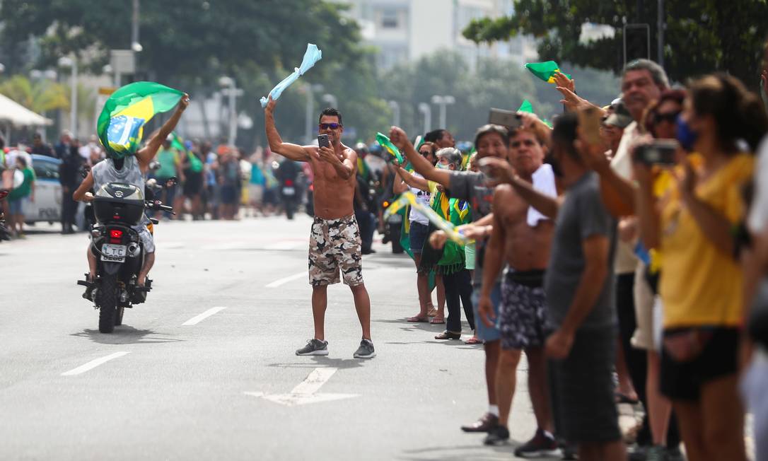 Apoiadores, a maioria sem máscara, aguardam a passagem do presidente pelo bairro do Flamengo Foto: PILAR OLIVARES / REUTERS