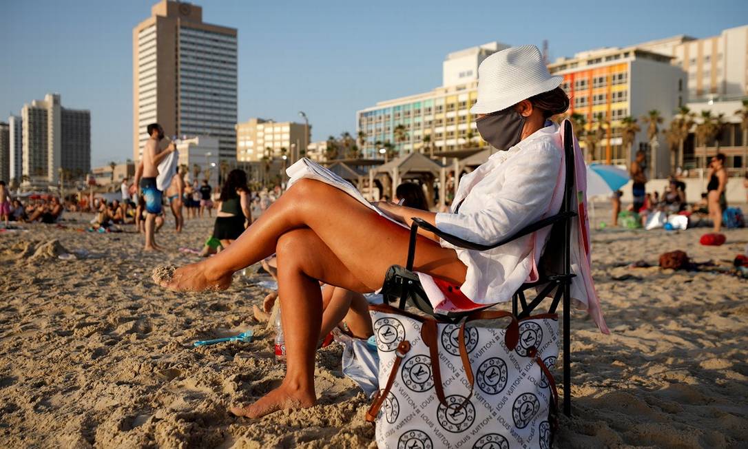 Banhista de máscara aproveita a praia em Tel Aviv, em Israel Foto: Amir Cohen / REUTERS