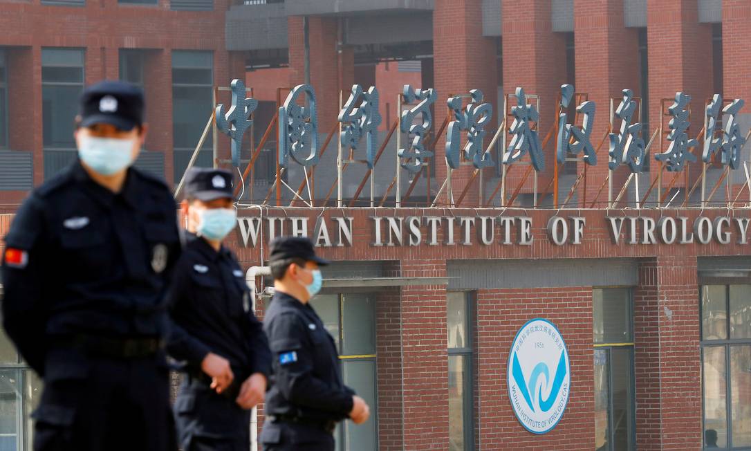Seguranças em frente ao Instituto de Virologia de Wuhan, na China, em fevereiro de 2021, durante visita de time da Organização Mundial da Saúde que investiga as origens da Covid-19 Foto: Thomas Peter / Reuters
