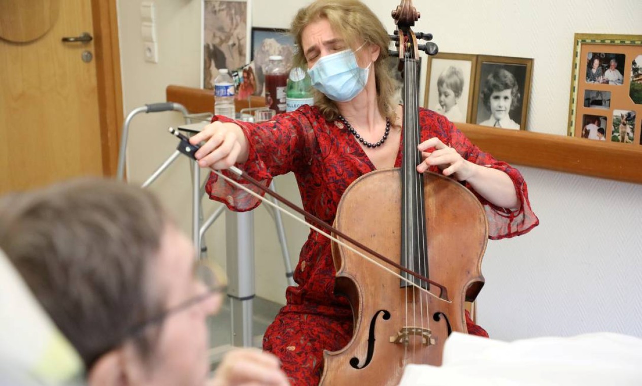 A violoncelista Claire Oppert toca música para acalmar o paciente Bernard Genin, 79, no asilo de fim de vida Jeanne Garnier em Paris, França, 21 de maio de 2021. Foto tirada em 21 de maio de 2021. REUTERS / Yiming Woo TPX IMAGENS DO DIA Foto: STAFF / REUTERS