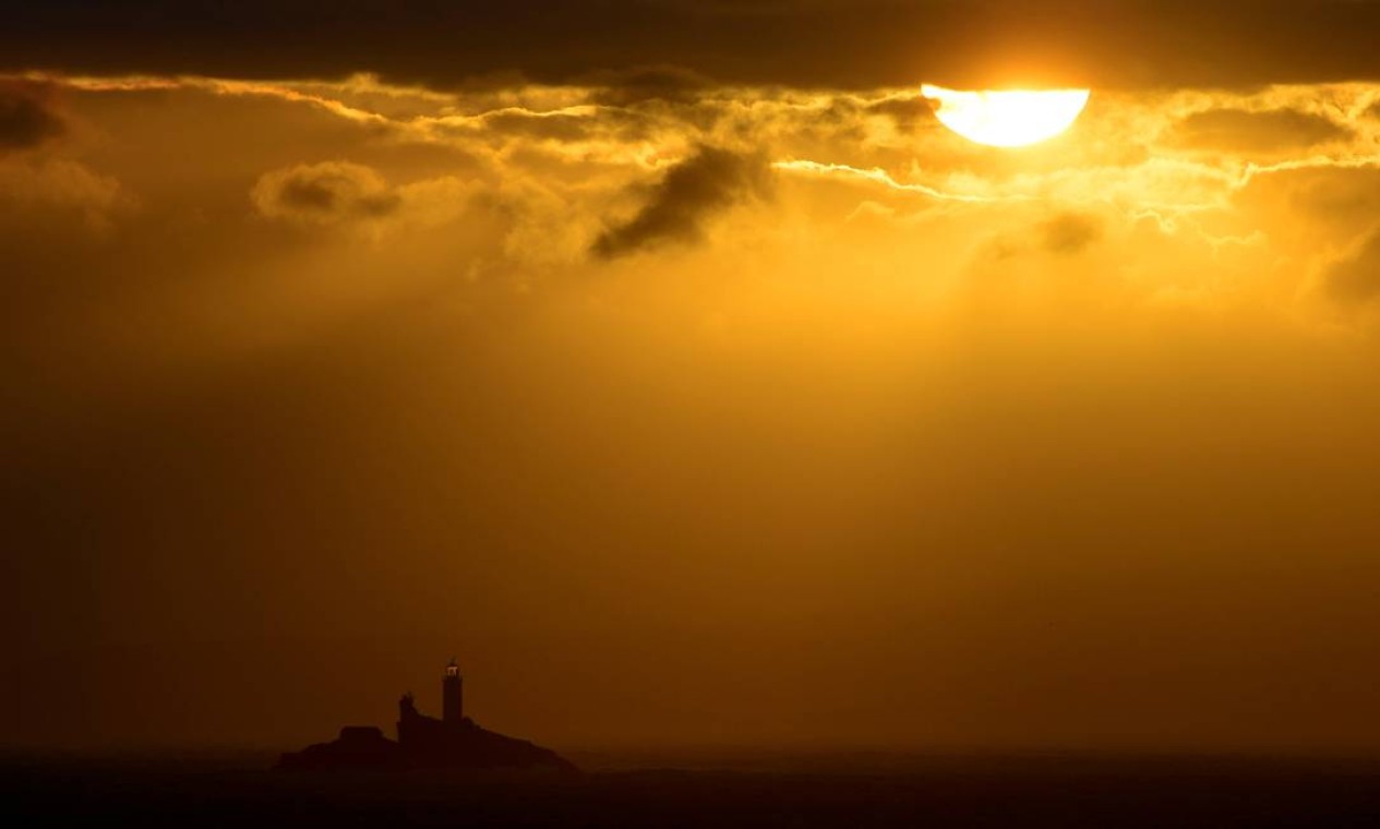 O farol de Godrevy é visto logo após o nascer do sol, em St Ives Bay, Cornwall, sudoeste da Inglaterra Foto: TOBY MELVILLE / REUTERS