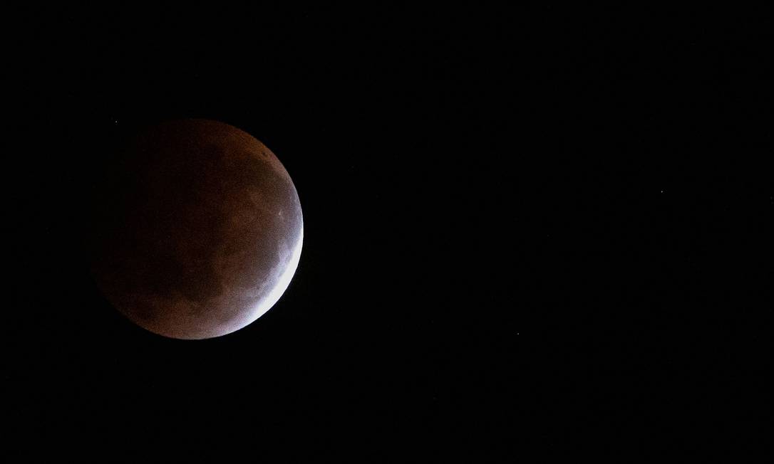 The moon is pictured above Suva in Fiji on May 26, 2021, during a total lunar eclipse as stargazers across the Pacific casted their eyes skyward to witness a rare "Super Blood Moon". (Photo by Leon LORD / AFP) Foto: LEON LORD / AFP