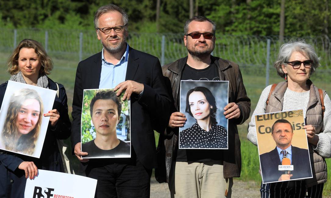Membros dos Repórteres sem Fronteiras posam com fotos de jornalistas bielorrussos detidos, entre eles Roman Protasevich, em Salcininkai, Lituânia Foto: PETRAS MALUKAS / AFP