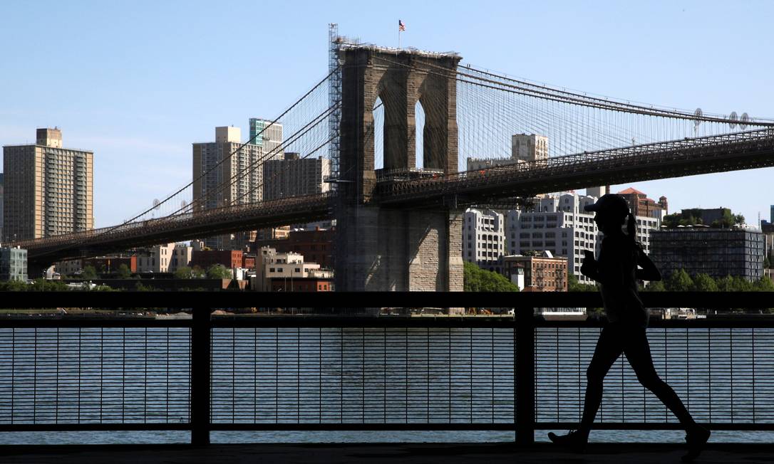 Una donna corre lungo l'East River Greenway vicino al ponte di Brooklyn a New York City.  I casi di Covid-19 sono diminuiti e più persone sono state vaccinate Immagine: BRENDAN MCDERMID / REUTERS