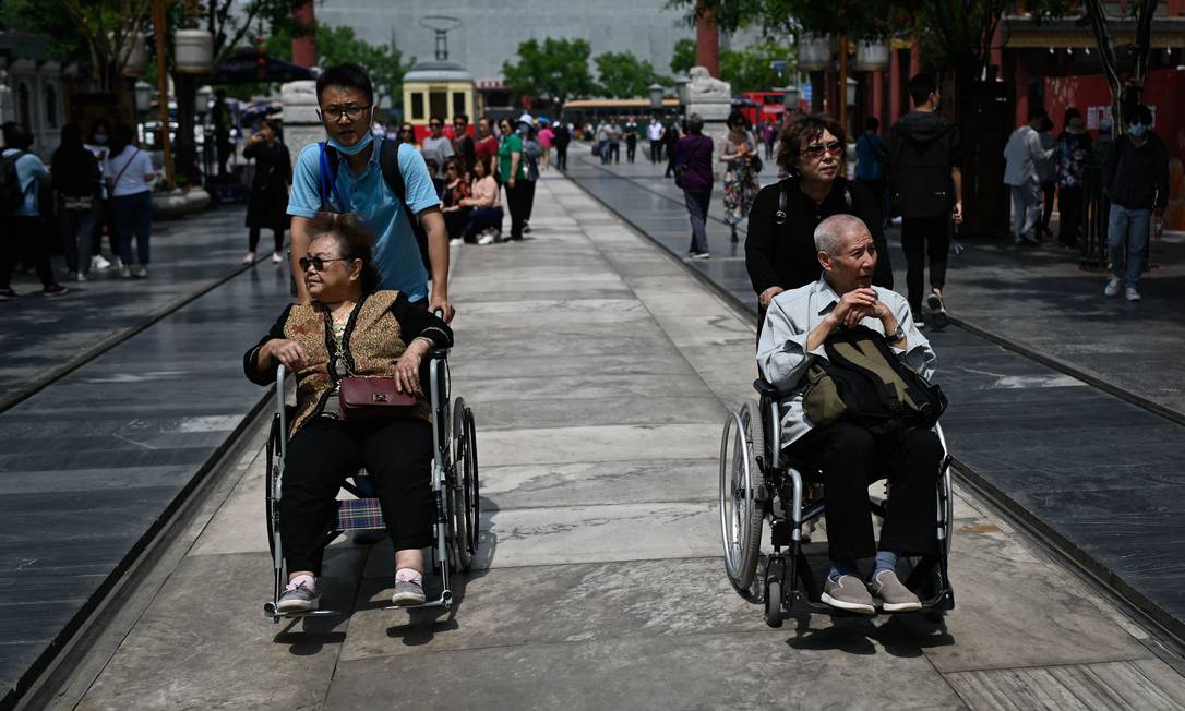 Idosos são empurrados em cadeiras de rodas numa rua de Pequim, China Foto: WANG ZHAO / AFP/11-05-2021