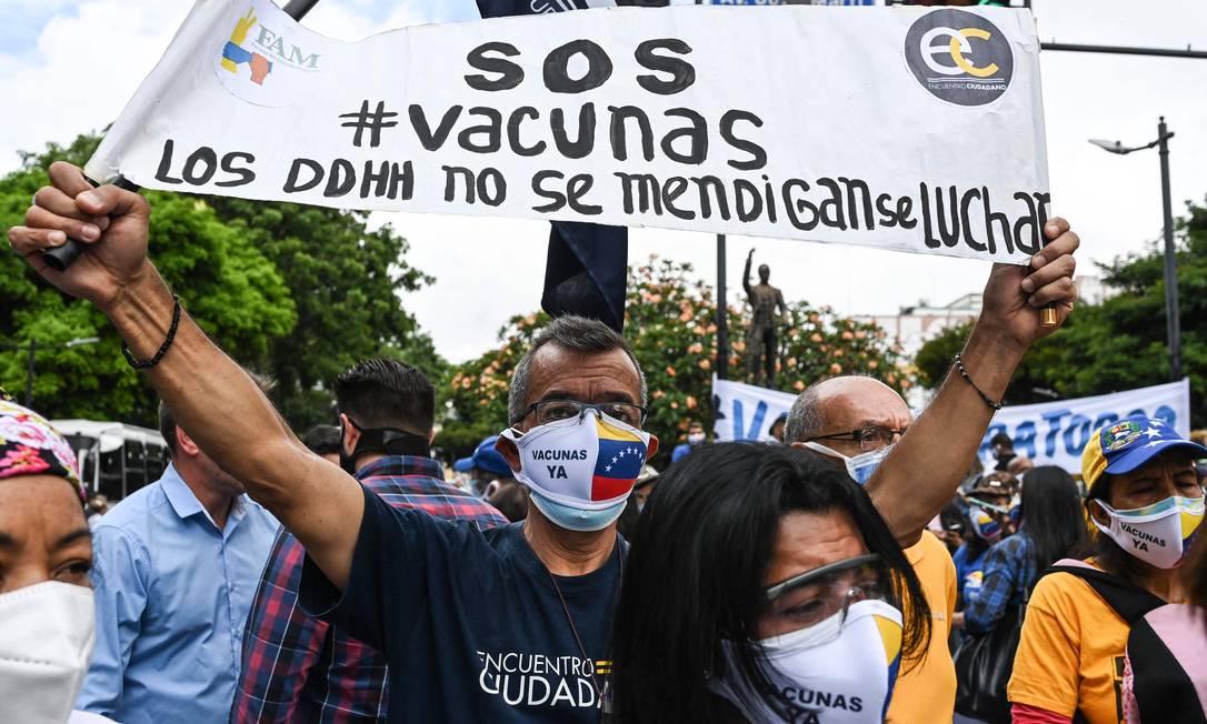 Ativista da oposição segura faixa que diz 'vacinação agora' durante protesto em Caracas, Venezuela Foto: YURI CORTEZ / AFP/28-05-2021