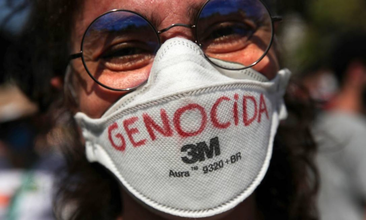 Manifestante exibe máscara de proteção com a palavra 'genocida', no Rio Foto: Ricardo Moraes / Reuters