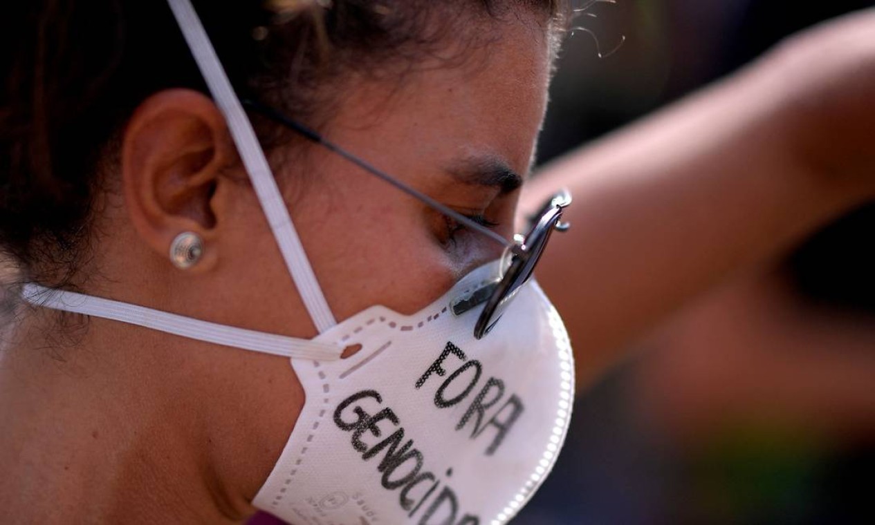 Mulher usa uma máscara com mensagem contra o presidente brasileiro Jair Bolsonaro, em Belo Horizonte, Minas Gerais Foto: Douglas Magno / AFP