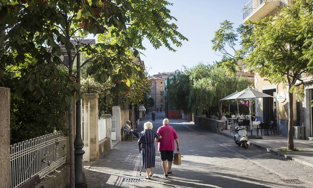 Casal caminha pelo centro histórico de Acciaroli, na Itália Foto: GIANNI CIPRIANO / NYT
