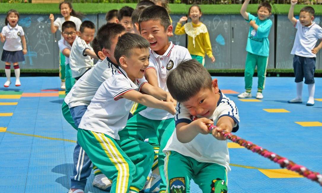 Crianças brincam em uma escola de jardim de infância em Yantai, no Leste da província de Shandong Foto: STR / AFP