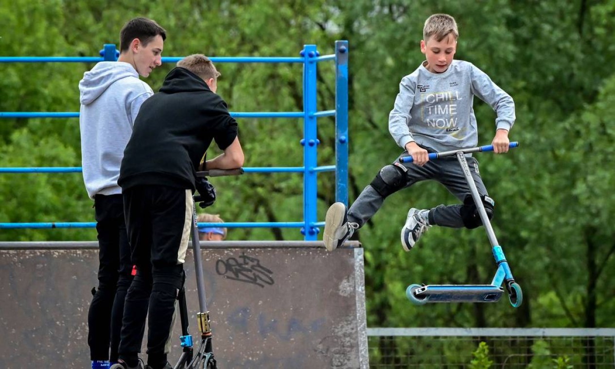 Adolescentes treinam manobras com patinetes em uma pista de skate na cidade de Chekhov, a cerca de 75 quilômetros de Moscou Foto: YURI KADOBNOV / AFP