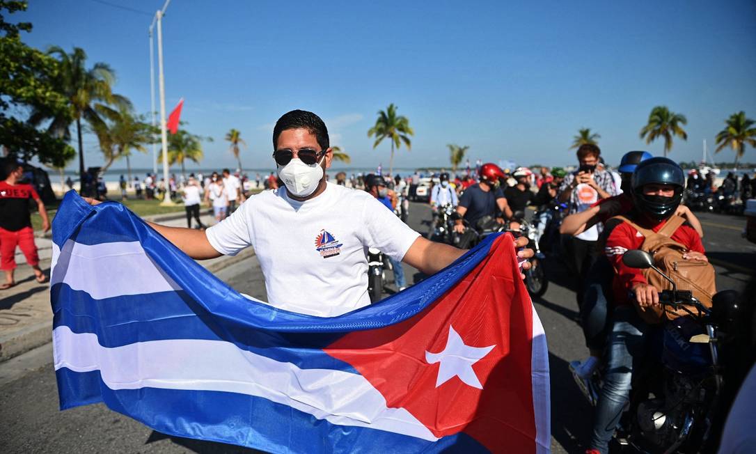 Homem carrega bandeira cubana na província de Cienfuegos, em Cuba, em protestos contra o embargo americano em maio de 2021 Foto: YAMIL LAGE / AFP
