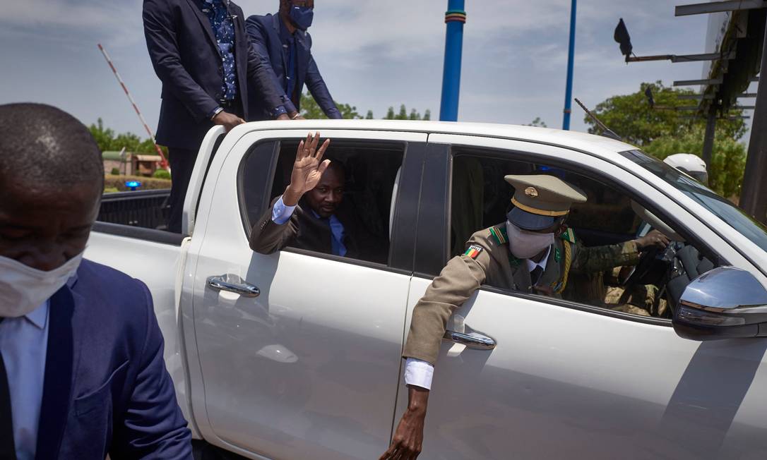 O novo presidente interino do Mali, o coronel Assimi Goita, que esteve por trás de dois golpes militares no país, acena para apoiadores após chegar de reunião em Gana com representantes de bloco da África Ocidental Foto: Michele Cattani / AFP
