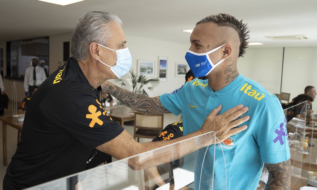 De máscaras, Tite e Everton Cebolinha se cumprimentam na Granja Comary Foto: Lucas Figueiredo/CBF