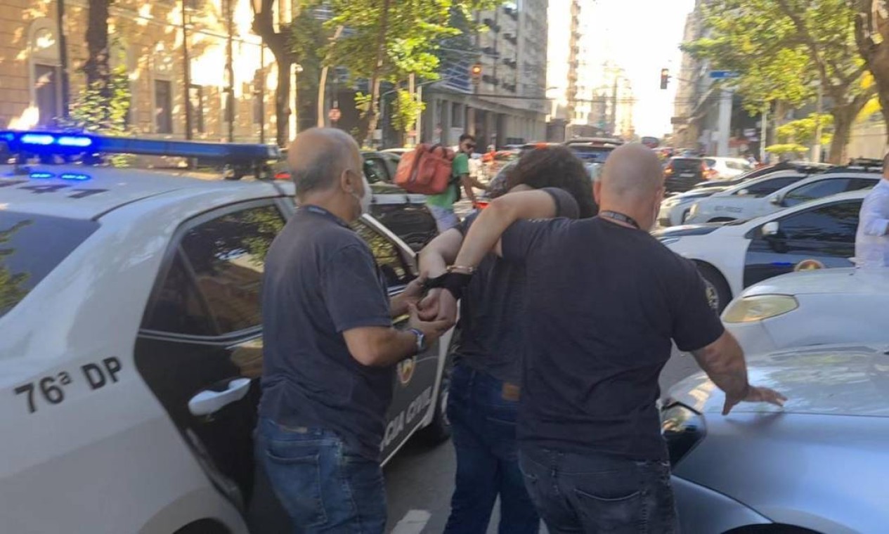 Momento em que agentes polciais da 76a DP (Icaraí) levam o criminoso algemado para a delegacia Foto: Divulgação
