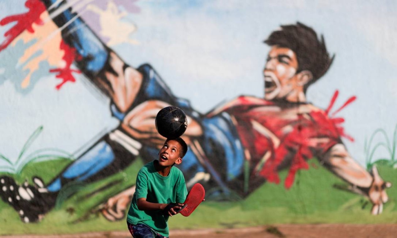 Criança joga futebol em rua do bairro Ceilândia, em Brasília Foto: UESLEI MARCELINO / REUTERS