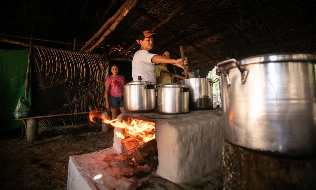 Mulheres se dividem no trabalho de preparo do alimento para os assentados Foto: Brenno Carvalho / Agência O Globo