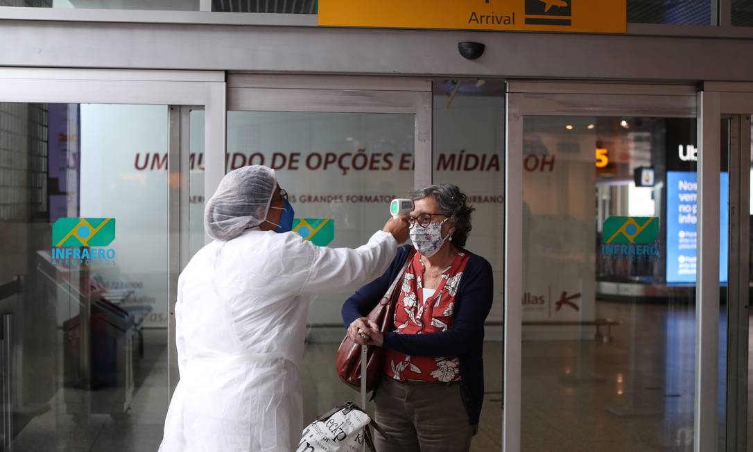 Profissional de saúde mede a temperatura de viajante em uma barreira sanitária ao chegar ao aeroporto de Congonhas, em São Paulo, Brasil Foto: AMANDA PEROBELLI / REUTERS