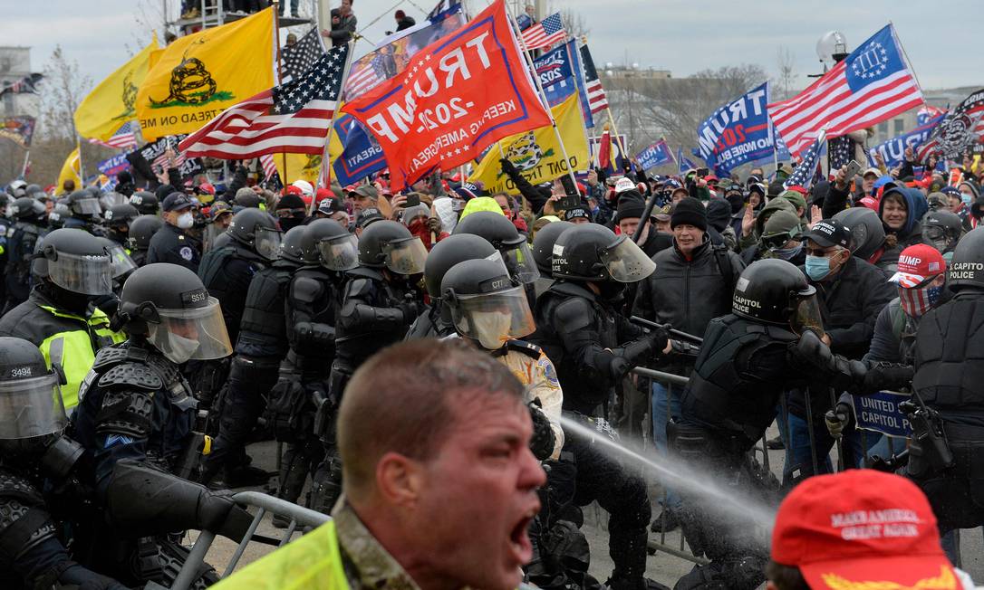 Apoiadores do ex-presidente americano Donald Trump se chocam com policiais ao tentar invadir o Capitólio em 6 de janeiro de 2021 Foto: Joseph Prezioso / AFP