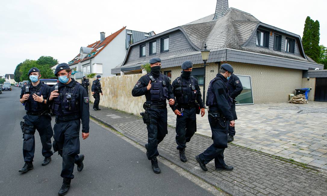 Policiais alemães caminham em frente a uma villa após uma incursão em Leverkusen, Alemanha Foto: THILO SCHMUELGEN / REUTERS/08-06-2021