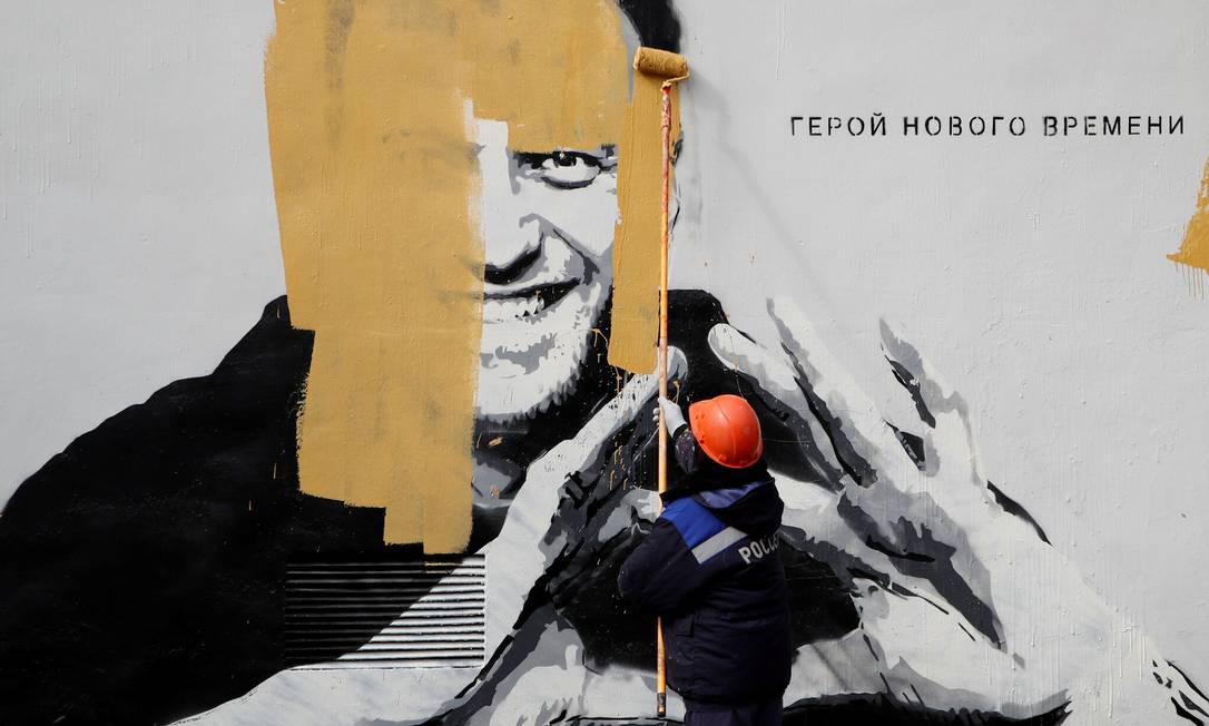 Um trabalhador pinta sobre um mural representando o opositor russo Alexei Navalny em São Petersburgo em abril Foto: Anton Vaganov / Reuters
