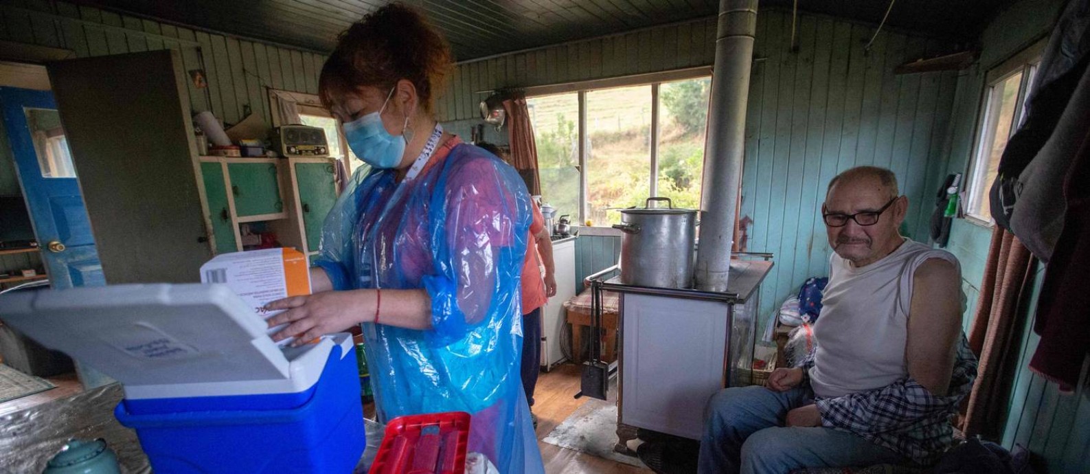 A enfermeira Ximena Ampuero vacina um idoso na ilha de Chiloé,1.230 quilômetros ao sul de Santiago; vacinação reduziu mortes entre idosos Foto: ALVARO VIDAL / AFP