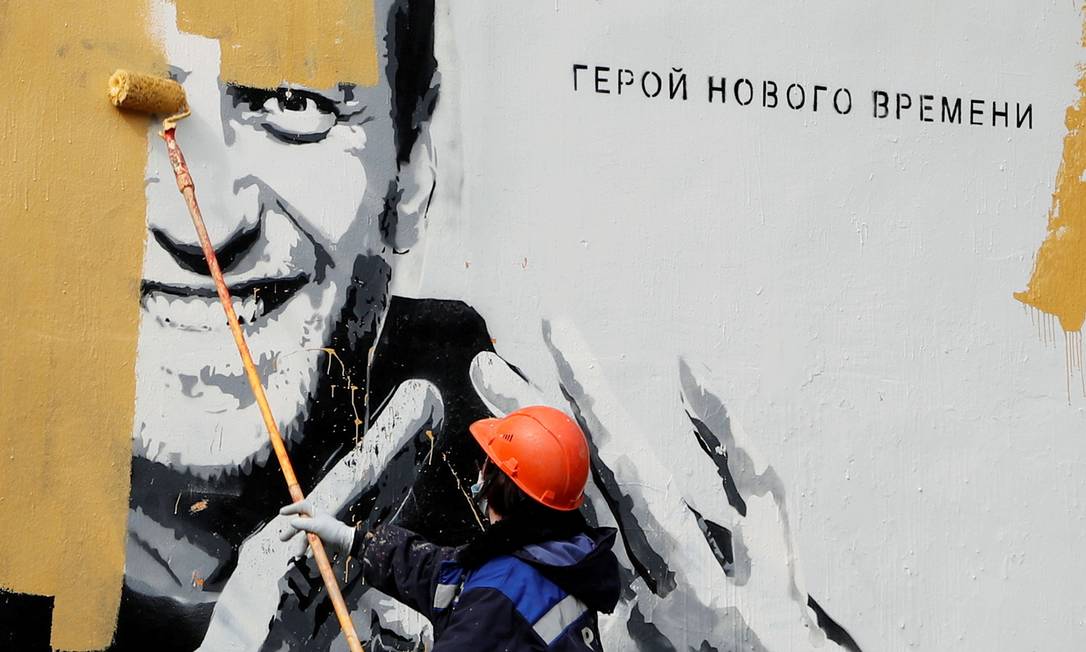 Homem pinta grafite com o rosto de Alexei Navalny e a frase "Homem da Nova Era" em São Petersburgo, no dia 28 de abril Foto: ANTON VAGANOV / REUTERS