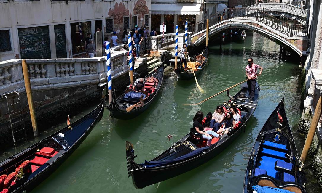 Turistas passeiam numa gôndola em Veneza, no começo de junho Foto: MIGUEL MEDINA / AFP