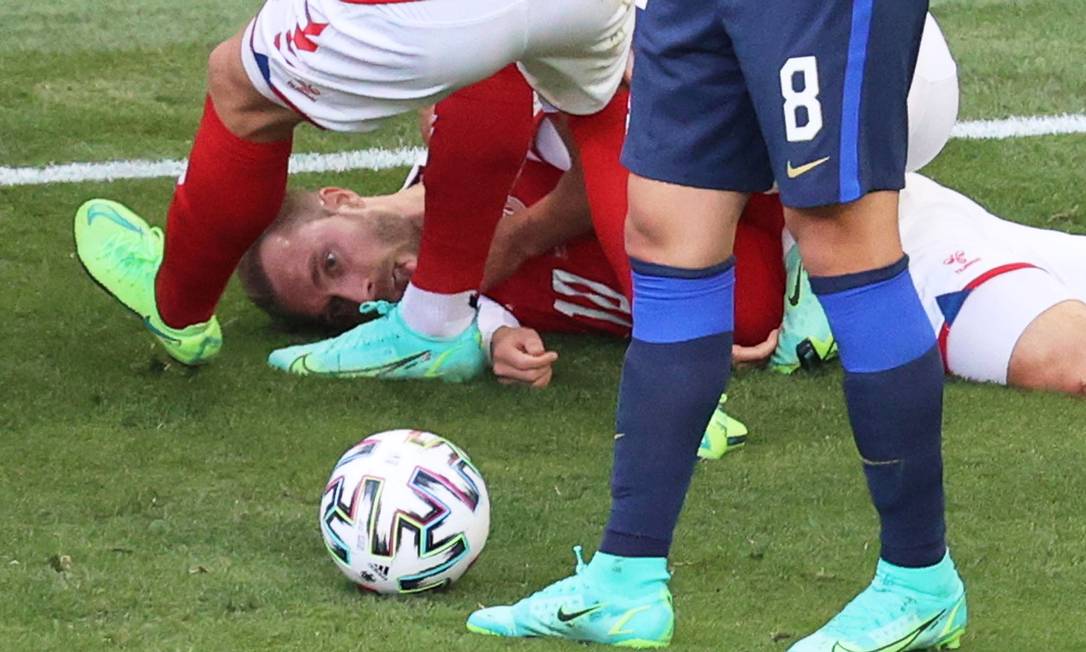 Eriksen é atendido por jogadores logo depois de cair desacordado em partida da Eurocopa Foto: WOLFGANG RATTAY / Pool via REUTERS