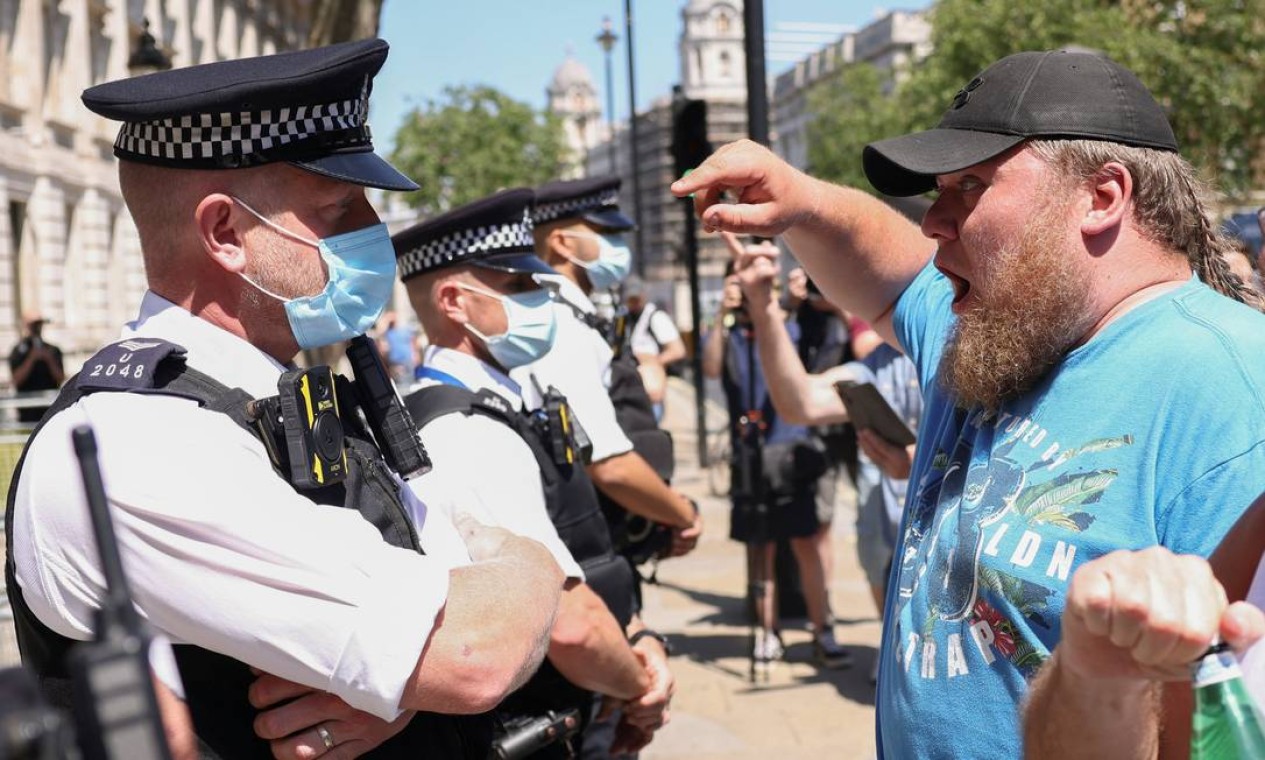 Manifestante fala com um policial durante protesto contra lockdown e antivacina, em Downing Street, em meio ao aumento de casos da COVID-19, em Londres Foto: HENRY NICHOLLS / REUTERS