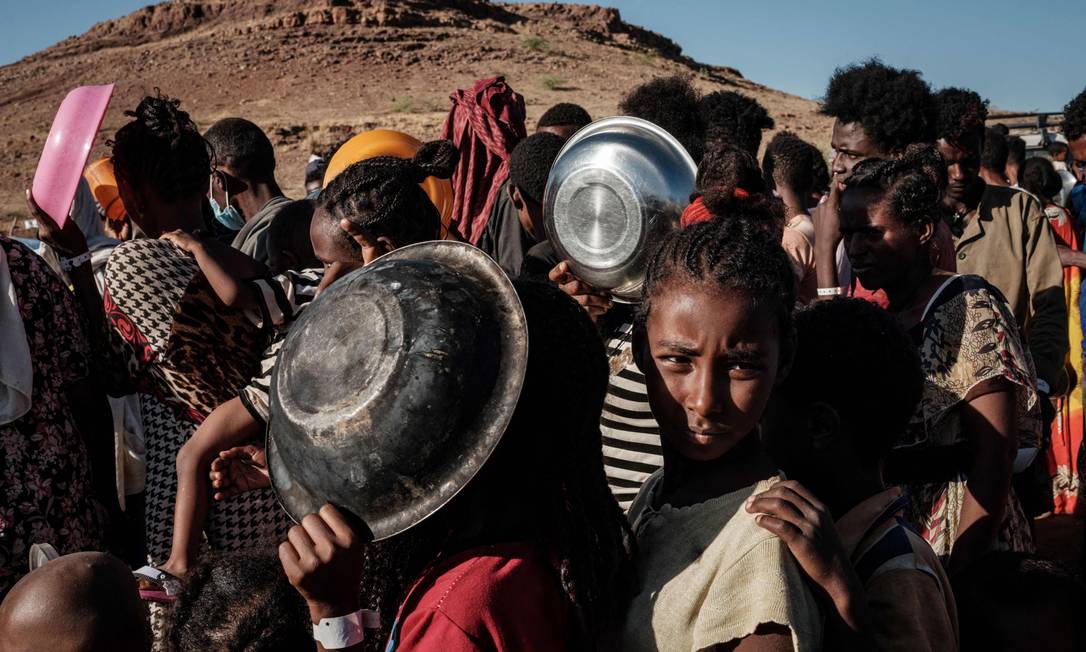 Crianças etíopes que fugiram da guerra em Tigré em fila para receber comida em um campo de refugiados no Sudão em dezembro de 2020 Foto: Yasuyoshi Chiba / AFP
