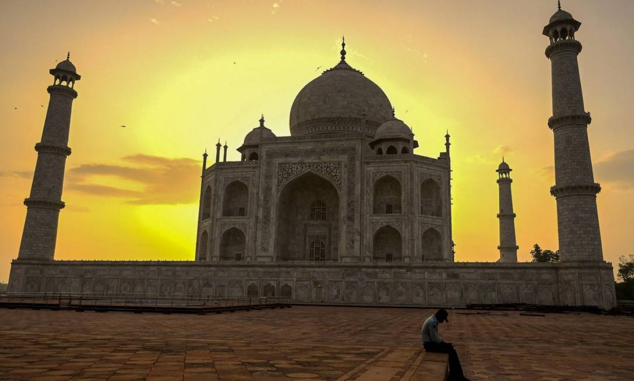 Guarda de segurança faz uma pausa enquanto o sol nasce atrás do Taj Mahal, depois que ele foi reaberto aos visitantes Foto: MONEY SHARMA / AFP