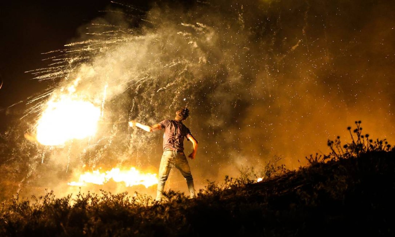 Manifestante palestino lança um projétil em chamas contra as forças israelenses durante uma manifestação a leste da Cidade de Gaza Foto: MAHMUD HAMS / AFP
