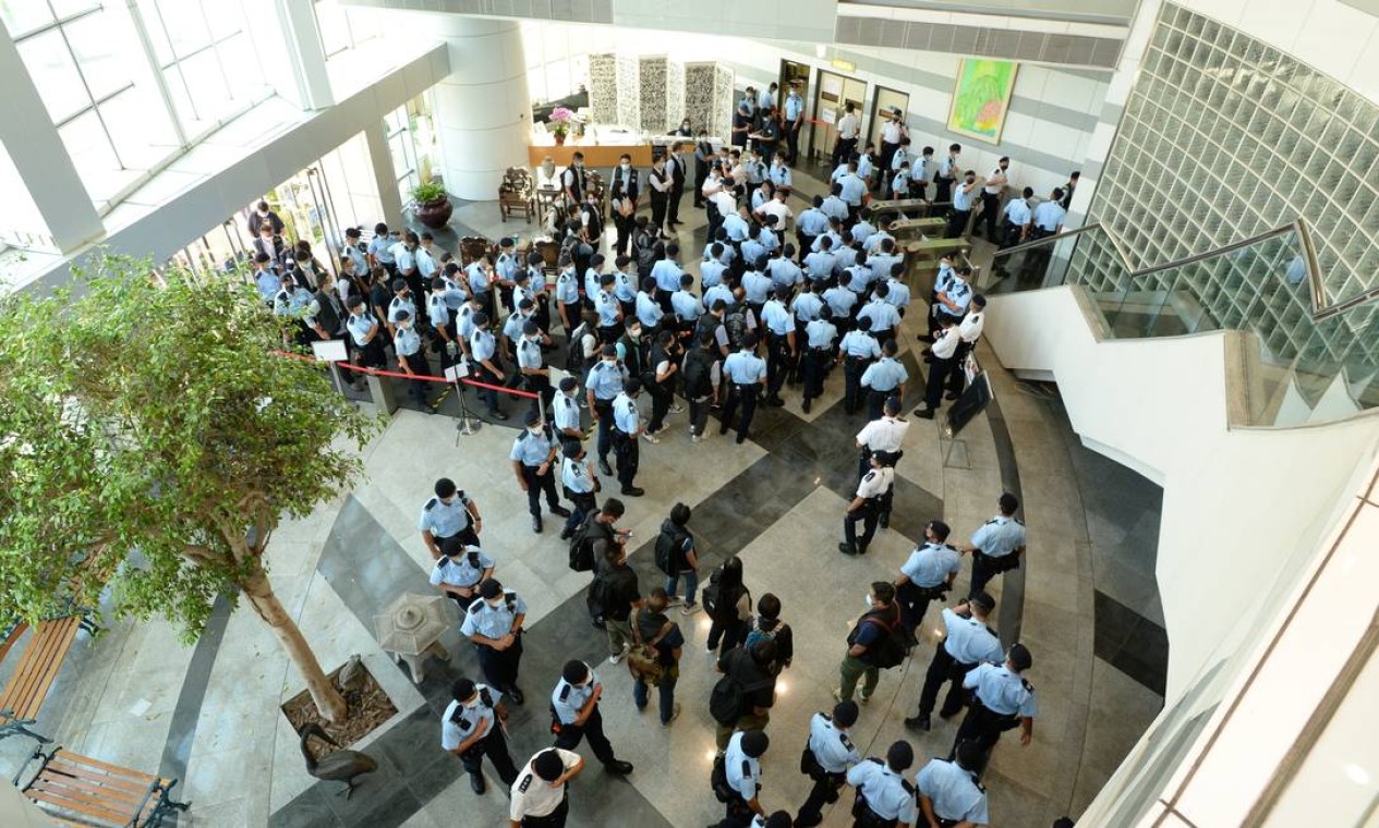 Policiais se reúnem na sede do Apple Daily, em Hong Kong, China Foto: APPLE DAILY / VIA REUTERS