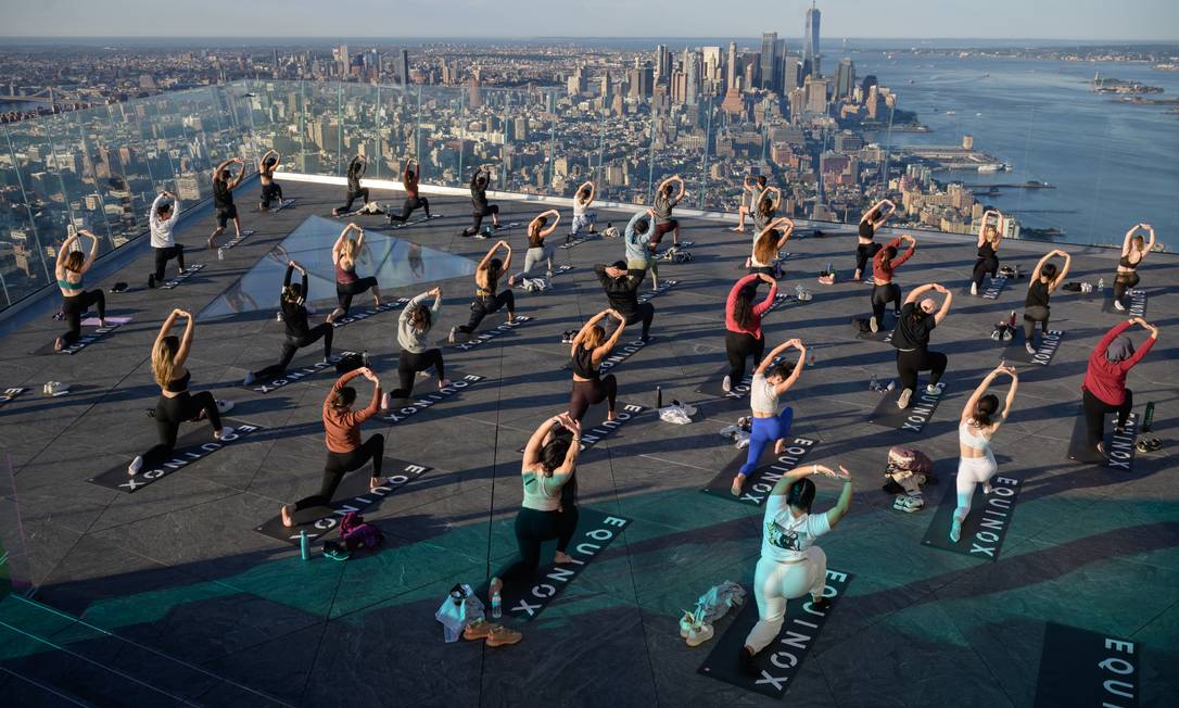 I praticanti di yoga seguono una lezione sull'Edge Observation Deck, pubblicizzato come il ponte di osservazione all'aperto più alto del West, con vista su Manhattan, New York.  Foto: ED JONES / AFP