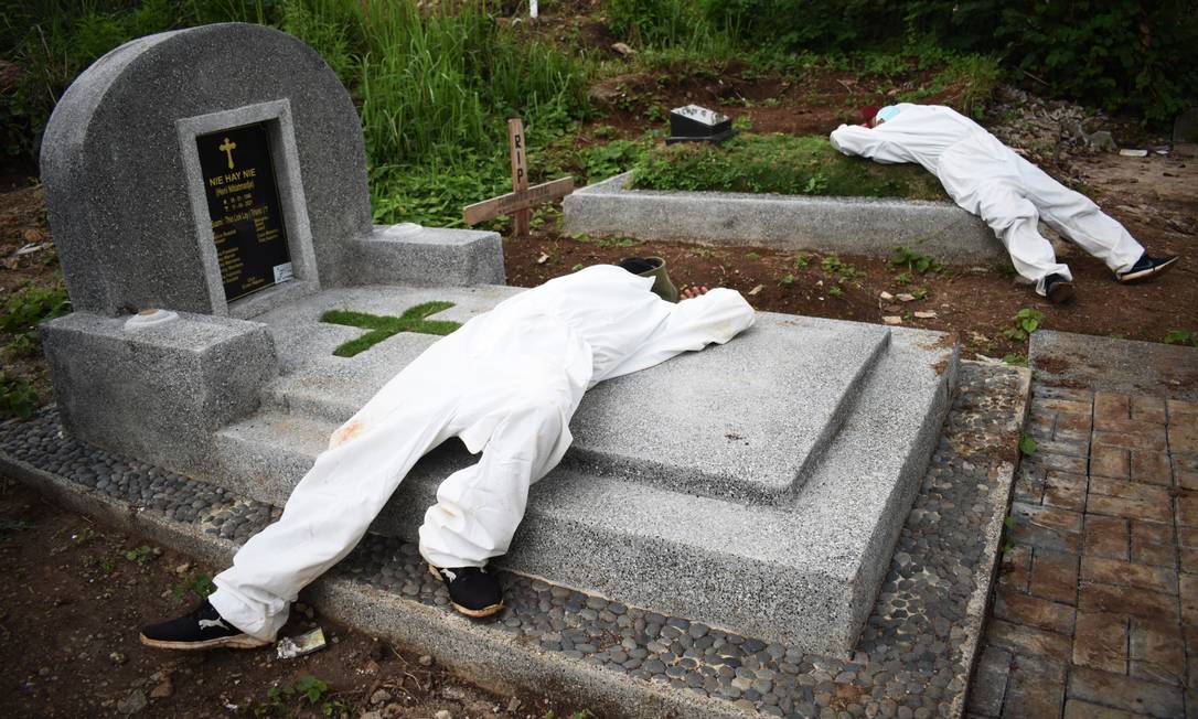 Becchini esausti riposano tra i funerali in un cimitero per le vittime di Covid-19 mentre le infezioni aumentano in Indonesia Foto: TIMUR MATAHARI / AFP