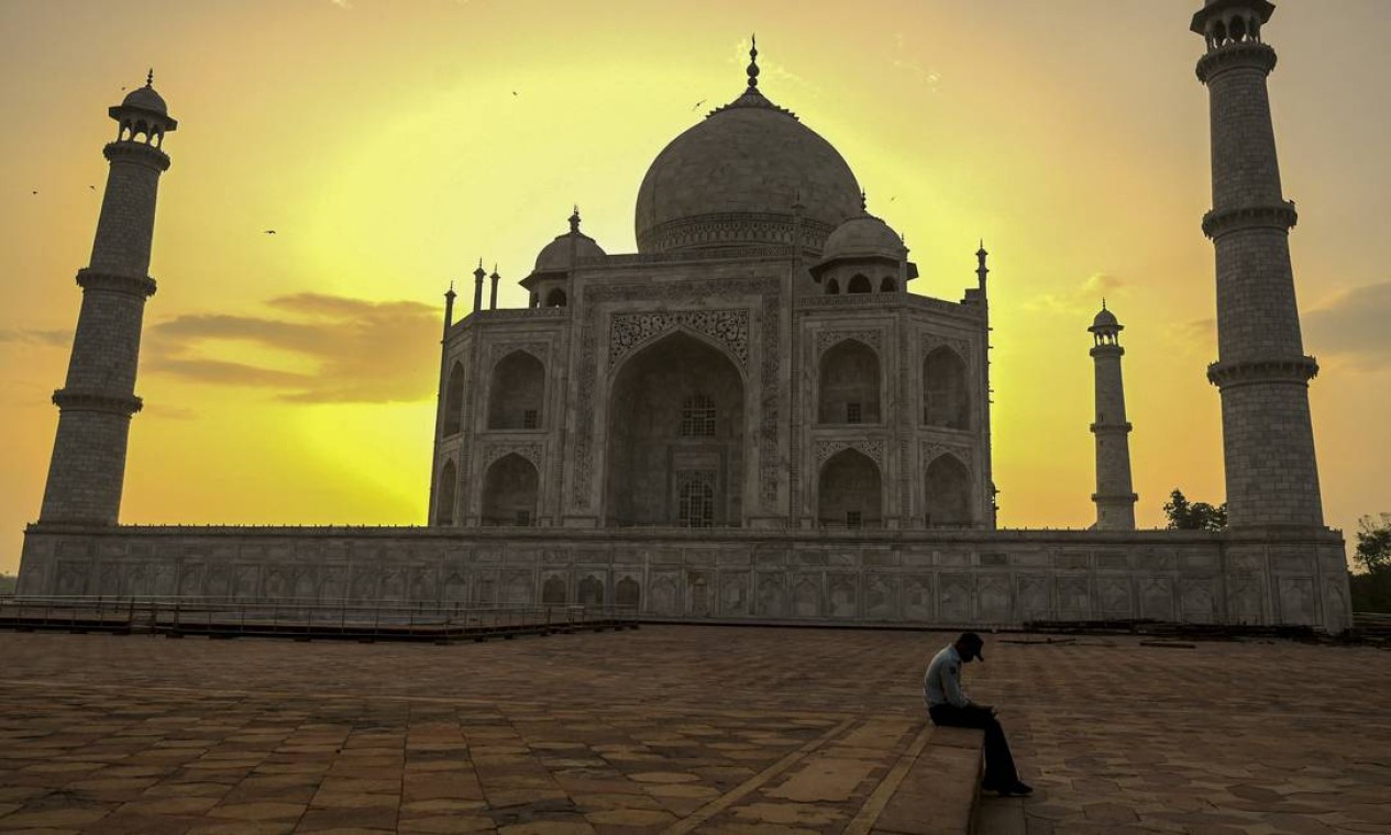 Guarda repousa durante o nascer do sol atrás do Taj Mahal, depois que o local foi reaberto aos visitantes, em Agra, Índia Foto: MONEY SHARMA / AFP