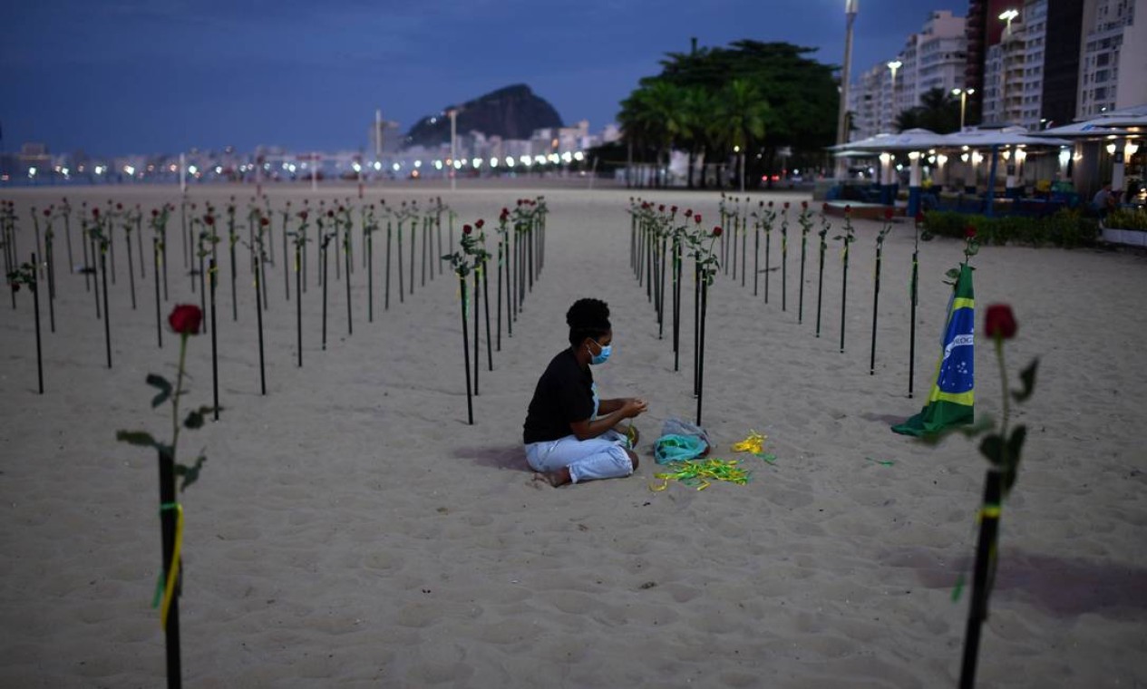 Voluntários espalharam 500 rosas vermelhas nas areias para lembrar o total de mortes Foto: LUCAS LANDAU / REUTERS