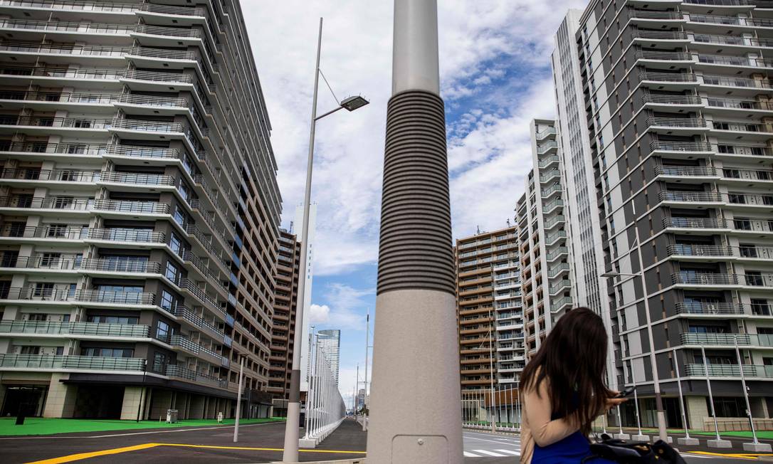 Jornalista é fotografada em vista frontal dos prédios da vila Foto: BEHROUZ MEHRI / AFP