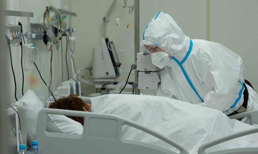 Trabalhador médico cuida de um paciente em um hospital temporário no Palácio de Gelo Krylatskoye, onde pacientes que sofrem da COVID-19 são tratados, em Moscou Foto: MOSCOW NEWS AGENCY / via REUTERS