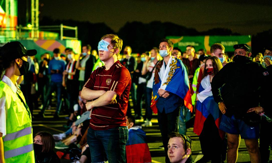 Torcedor da russo usa uma máscara sobre o nariz na fanzone, em Moscou, durante a partida de futebol da Eurocopa entre a seleção e Bélgica. Moscou fechou sua fanzone e proibiu reuniões de mais de mil pessoas por causa de um aumento nos casos da Covid-19 Foto: DIMITAR DILKOFF / AFP