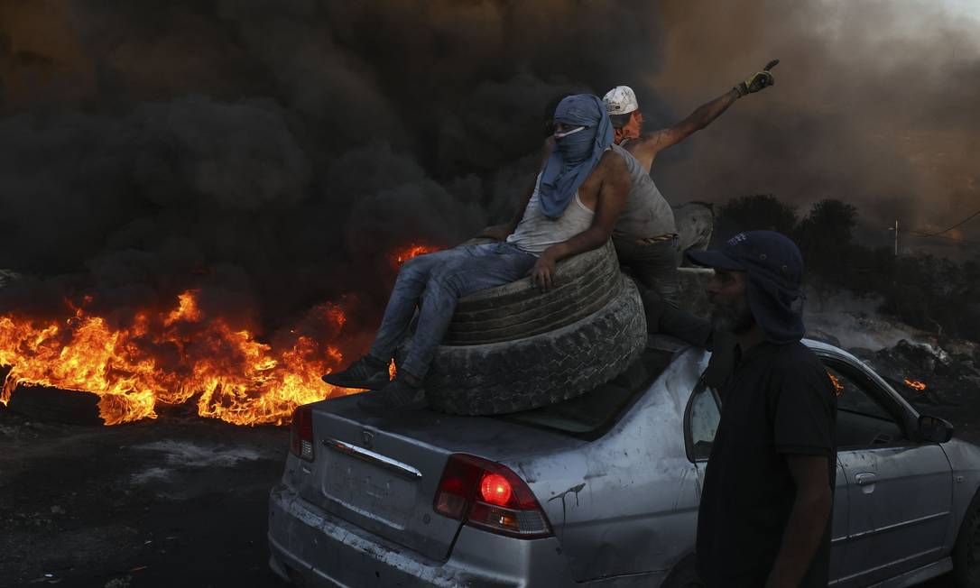 Palestinesi bruciano pneumatici durante una manifestazione contro l'espansione di un insediamento ebraico su un terreno nel villaggio di Beita, vicino alla città di Nablus, in Cisgiordania. Fotografo: Abbas Momani/AFP