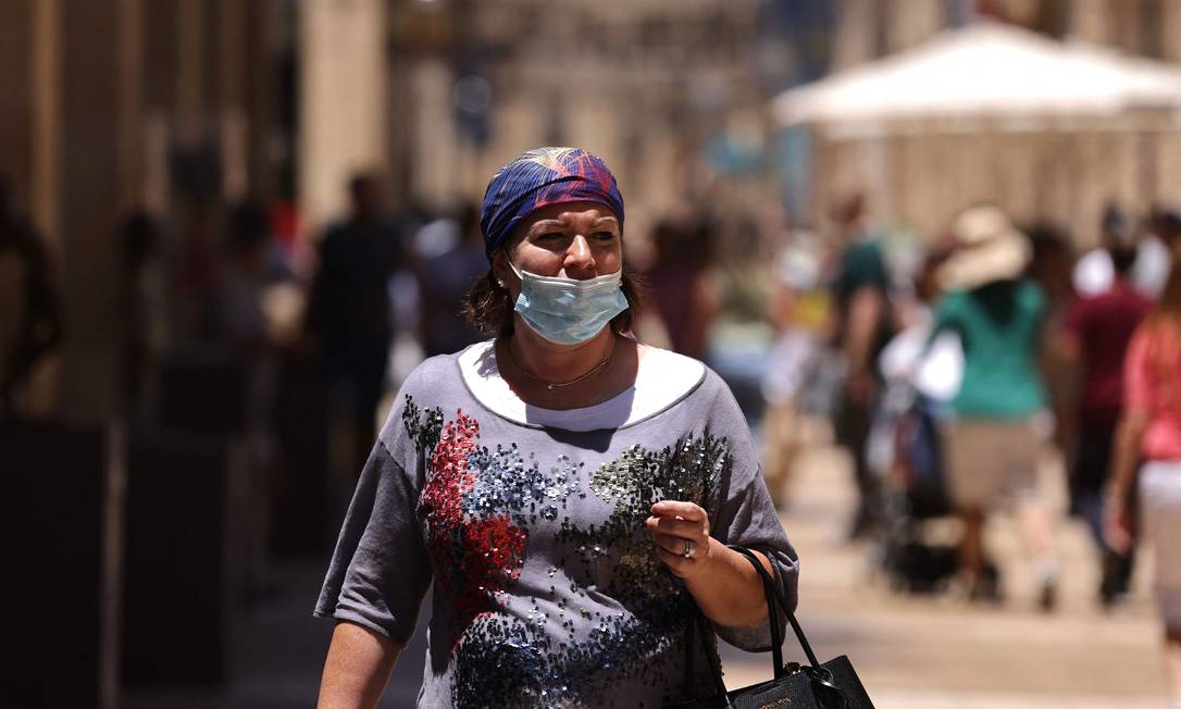 Mulher israelense usa máscara abaixo do nariz em Jerusalém Foto: EMMANUEL DUNAND / AFP