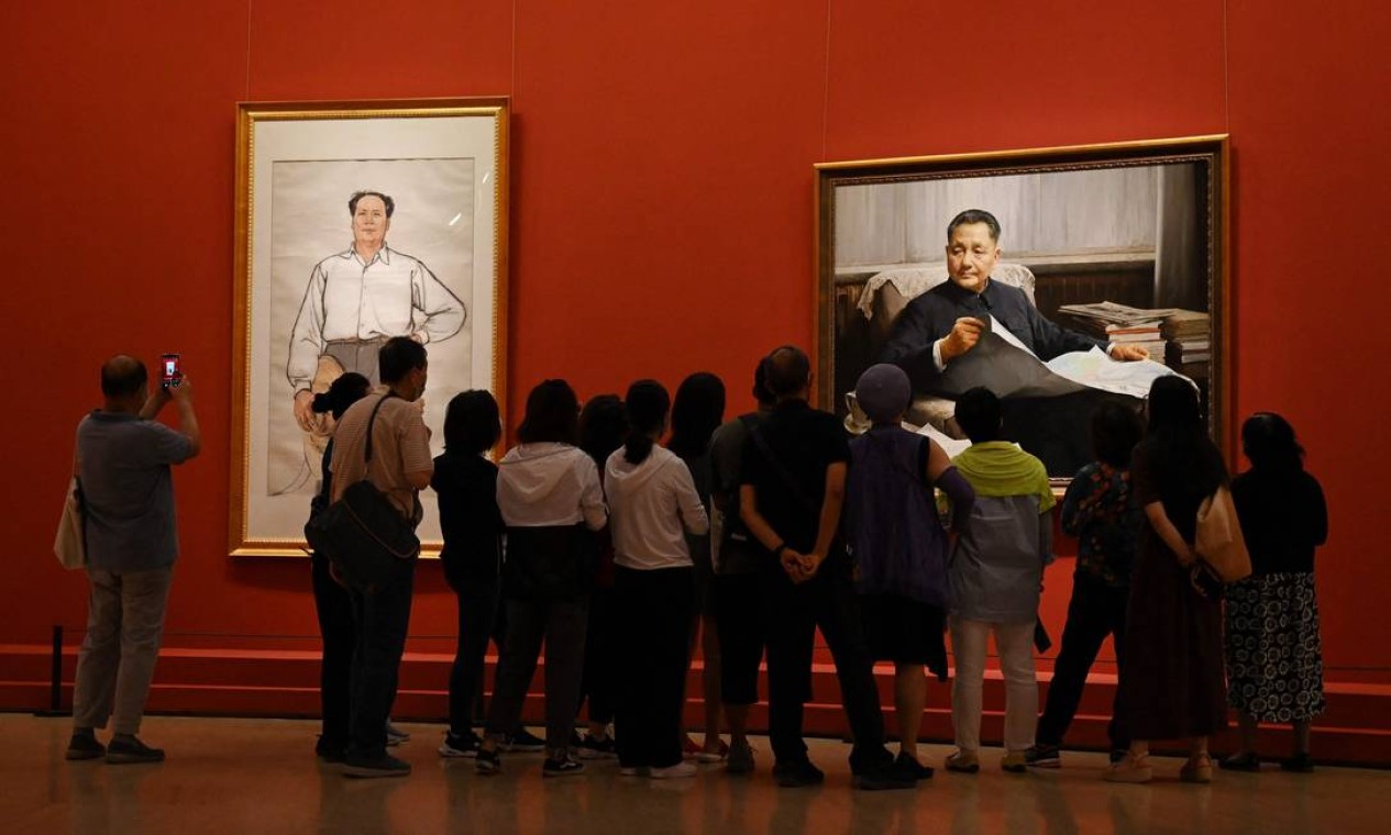 Os visitantes de exposição em Pequim diante de pinturas dos líderes comunistas Mao Tsé-tung e Deng Xiaoping Foto: GREG BAKER / AFP