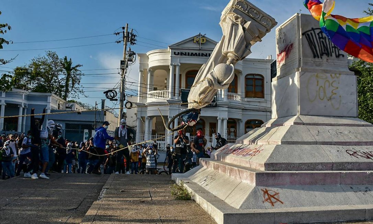 Manifestantes derrubam estatua de Cristóvão Colombo durante uma manifestação contra o governo em Barranquilla, Colômbia Foto: MERY GRANDOS HERRERA / AFP